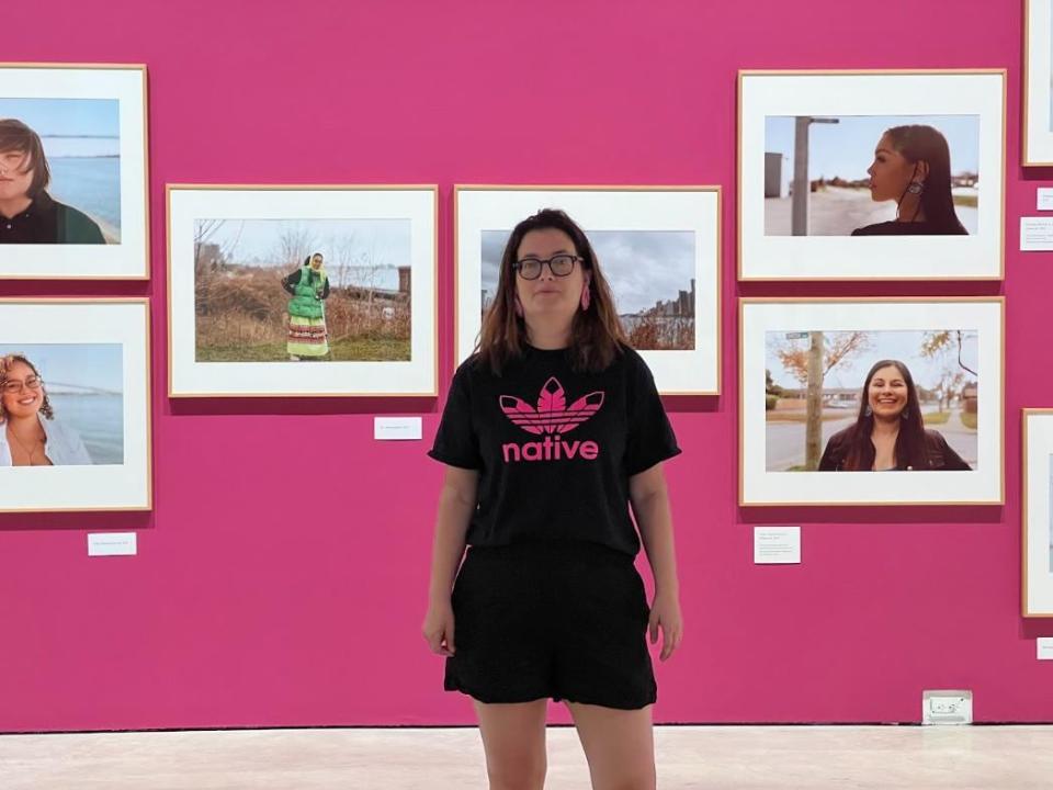 Julie Rae Tucker curated the Waawiiatanong Forever exhibit in collaboration with Jace Pillon, co-ordinator Shane Lyon and photographer Shayenna Nolan. Rae Tucker stands in front of some of the portraits displayed. 