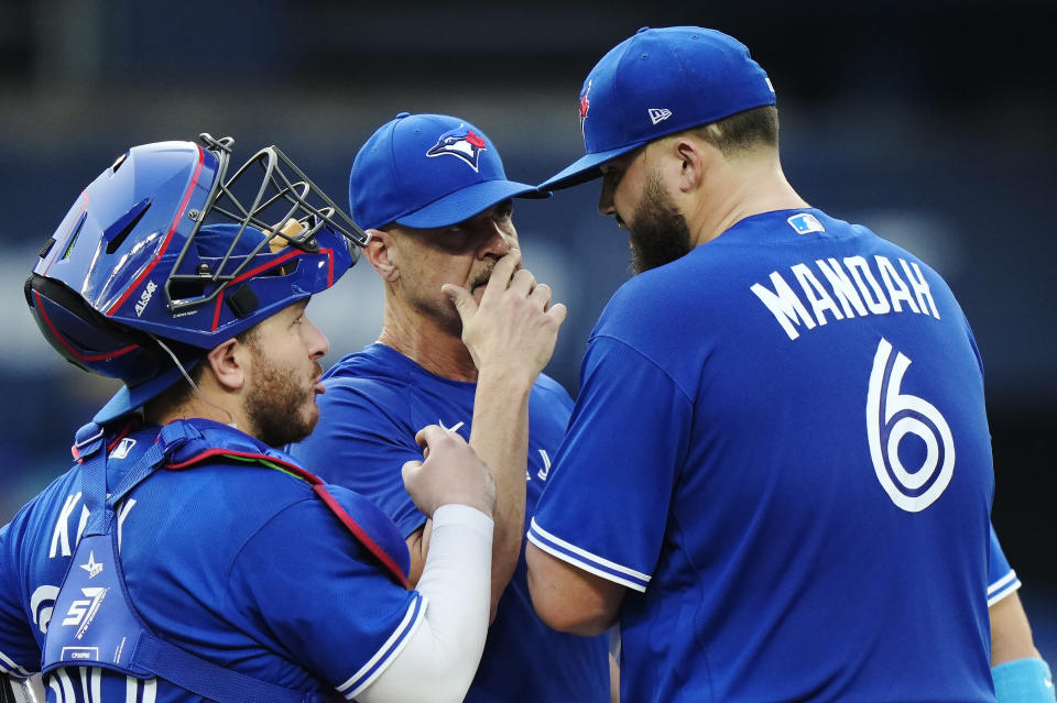 Toronto Blue Jays starting pitcher Alek Manoah (6) meets on the mound with catcher Alejandro Kirk and pitching coach Pete Walker during the second inning of the team's baseball game against the Milwaukee Brewers on Wednesday, May 31, 2023, in Toronto. (Frank Gunn/The Canadian Press via AP)