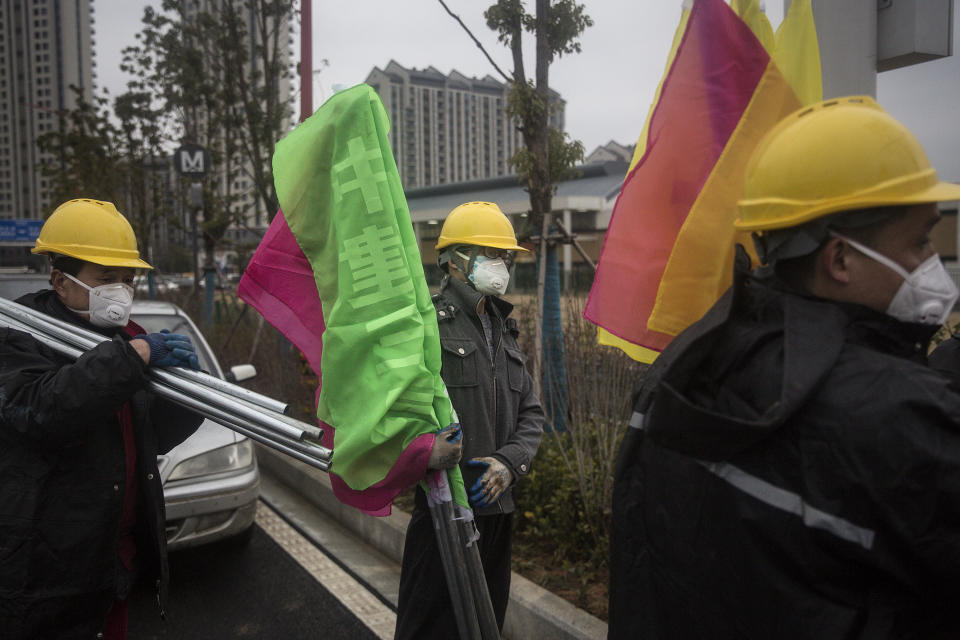 Worker put flags at a field hospital. Wuhan Leishenshan hospital will be completed on February 5, with a capacity of 1300 beds. Source: Stringe/Getty Images