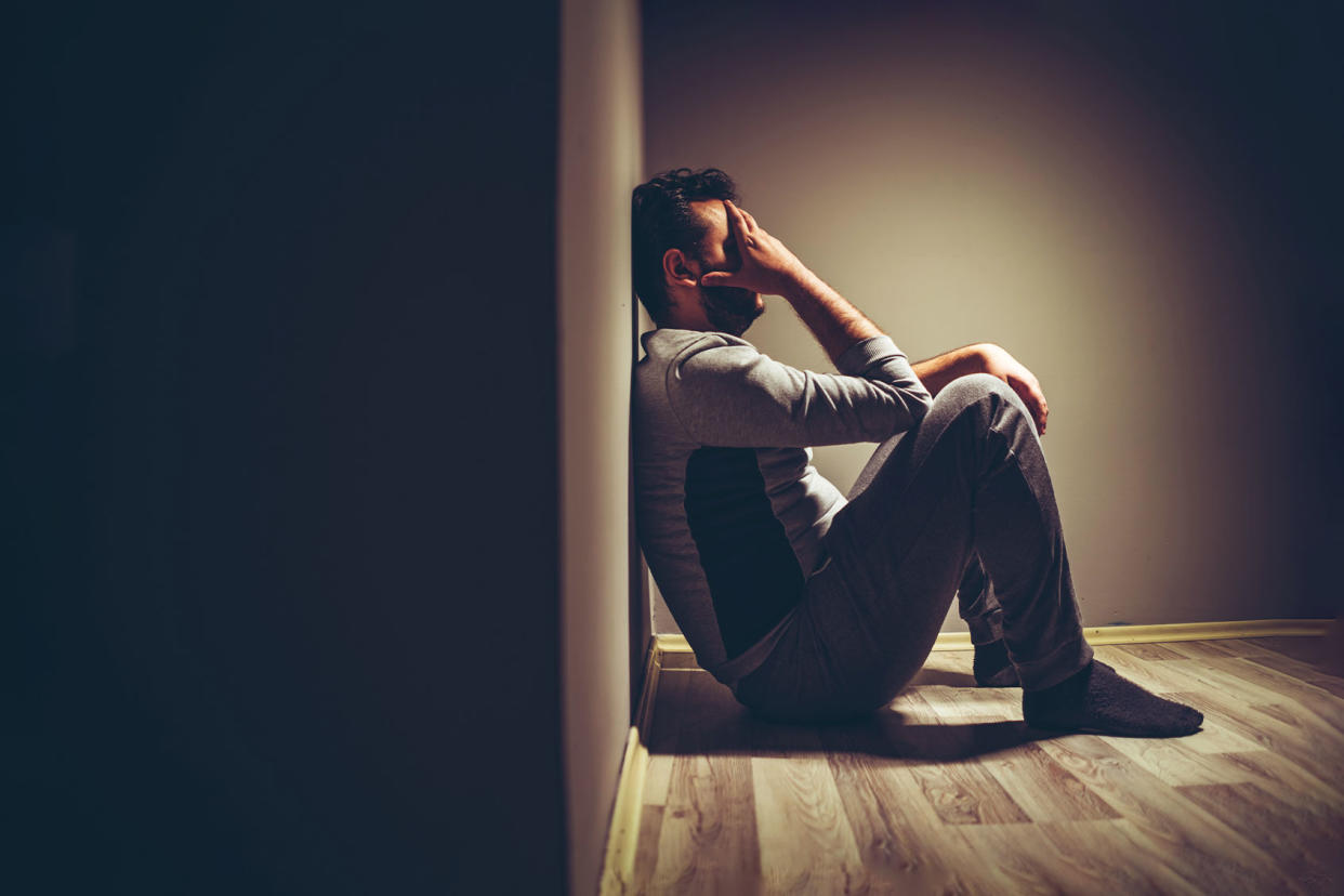 Young upset man sitting on floor Getty Images/urbazon