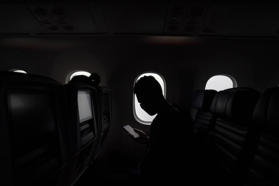 A foreign visitor looks at his smartphone as a plane approaches the Narita International Airport on July 10, 2021, in Narita, near Tokyo. Japan’s massive security apparatus for the upcoming Summer Olympics is raising complaints that the nation, during the weeks of the Games, will look more like authoritarian North Korea or China than one of the world’s most powerful, vibrant democracies. (AP Photo/Jae C. Hong)