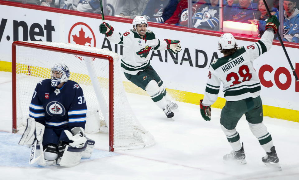 Minnesota Wild's Mats Zuccarello (36) and Ryan Hartman (38) celebrate Hartman's goal against Winnipeg Jets goaltender Connor Hellebuyck (37) during the second period of an NHL hockey game, Wednesday, March 8, 2023 in Winnipeg, Manitoba. (John Woods/The Canadian Press via AP)