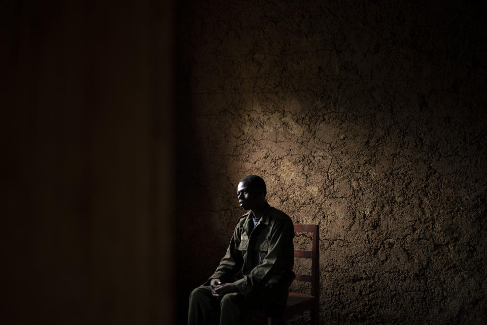 In this Sept. 7, 2019 photo, Jean Claude Masengesho sits in his house during an interview in Kinigi, Rwanda. The 21-year old lives with his parents and helps them farm potatoes. About once a week, the he earns a little extra money helping tourists carry their bags up the mountain, totaling about $45 a month. He would like to someday become a tour guide, which would earn him about $320 monthly. (AP Photo/Felipe Dana)