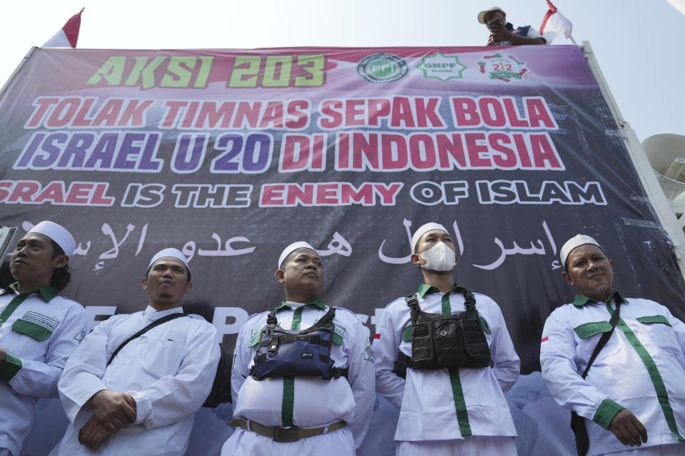 Protesters stand during a protest in Jakarta, Indonesia, Monday, March 20, 2023. Hundreds of conservative Muslims have marched to the streets Monday in Indonesia's capital to protest against the Israeli team's participation in the FIFA World Cup Under-20 in Indonesia.(AP Photo/Achmad Ibrahim)