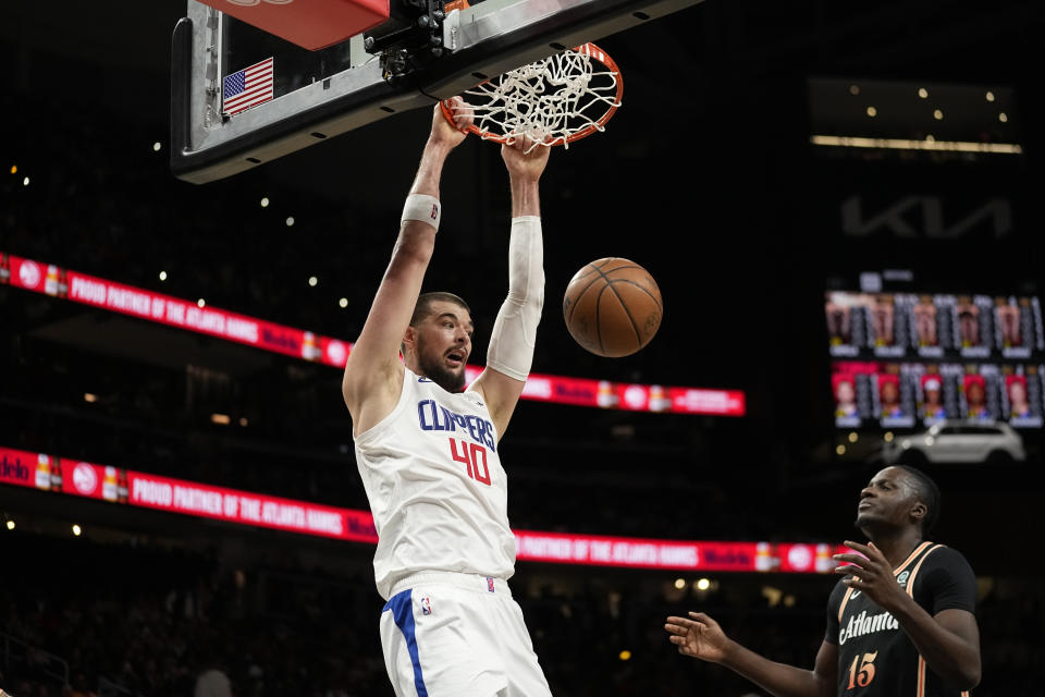 Los Angeles Clippers center Ivica Zubac (40) scores as Atlanta Hawks forward Clint Capela (15) looks on during the first half of an NBA basketball game Saturday, Jan. 28, 2023, in Atlanta. (AP Photo/John Bazemore)