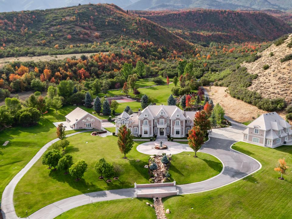 several structures on a compound connected by a driveway at a property in Utah nestled among hills