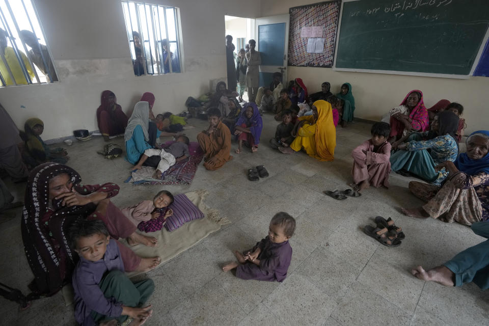 Women and children take shelter in a school after fleeing from their villages of costal areas due to Cyclone Biparjoy approaching, in Gharo near Thatta, a Pakistan's southern district in the Sindh province, Wednesday, June 14, 2023. In Pakistan, despite strong winds and rain, authorities said people from vulnerable areas have been moved to safer places in southern Pakistan's districts. With Cyclone Biparjoy expected to make landfall Thursday evening, coastal regions of India and Pakistan are on high alert. (AP Photo/Fareed Khan)