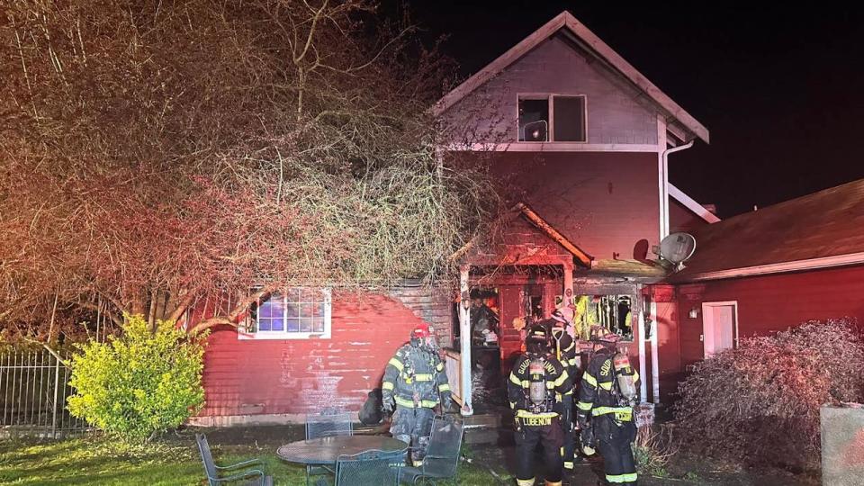 <div>Firefighters at the scene of an overnight house fire that displaced 10 residents on Tuesday. Crews are investigating what caused the fire. Photo: South County Fire</div>