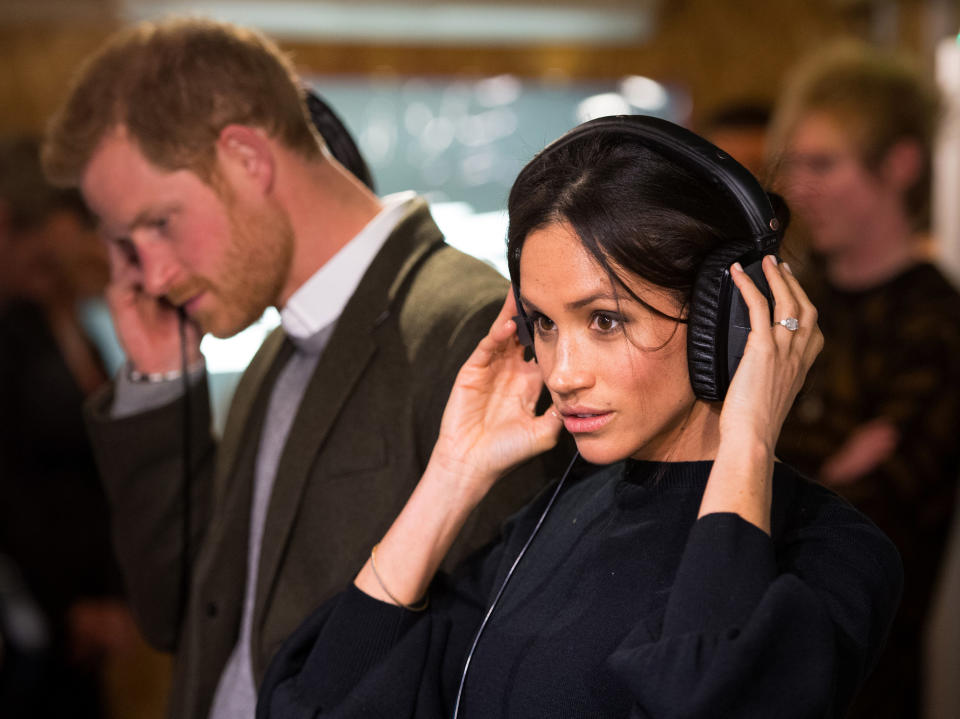 Britain's Prince Harry and his fiancée US actress Meghan Markle listen to a broadcast through headphones during a visit to Reprezent 107.3FM community radio station in Brixton, south west London on January 9, 2018.   / AFP PHOTO / POOL / Dominic Lipinski        (Photo credit should read DOMINIC LIPINSKI/AFP via Getty Images)