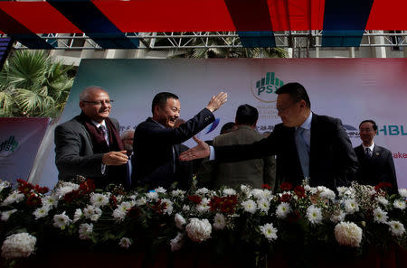 Nadeem Naqvi (L), Managing Director of the Pakistan Stock Exchange, shakes hands with Chinese officials after signing an agreement for a Chinese-led consortium to buy a strategic stake in PSX in Karachi, Pakistan, January 20, 2017. REUTERS/Akhtar Soomro/File Photo