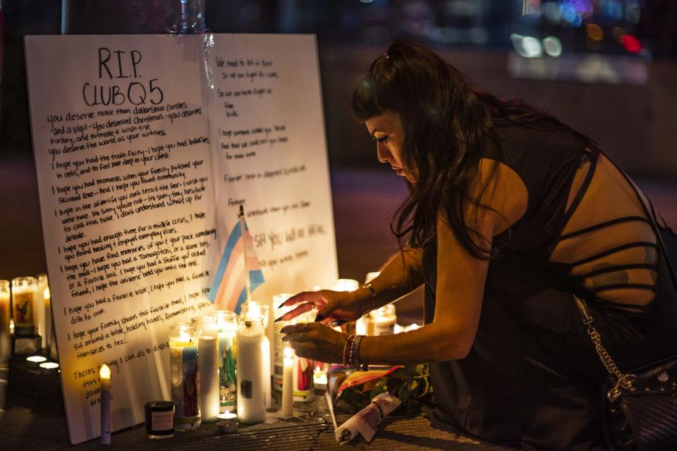 People light up candles in West Hollywood, Calif., at a makeshift memorial for the victims of the fatal shooting at Club Q in Colorado Springs, Colo.,