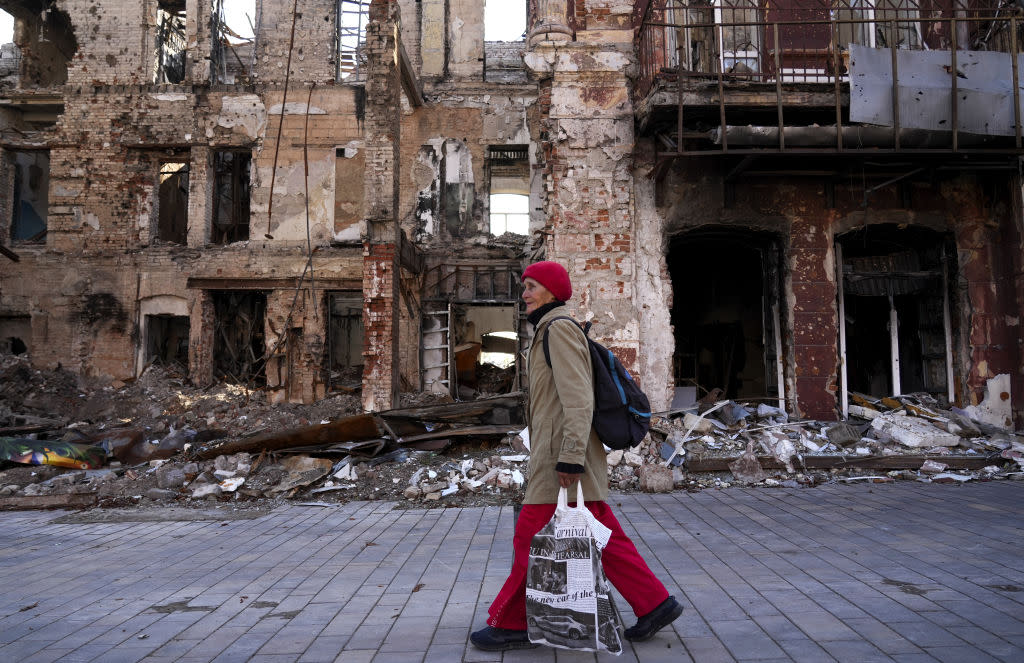  A woman walks past a destroyed building in Mariupol, Ukraine. 