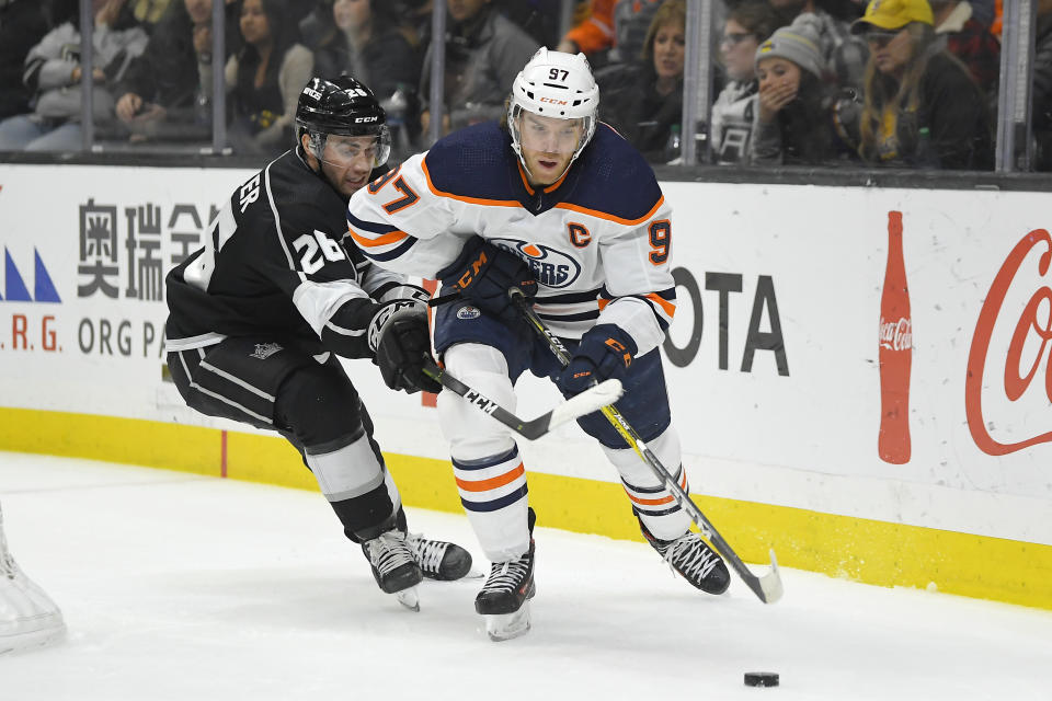 Edmonton Oilers center Connor McDavid, right, moves the puck while under pressure from Los Angeles Kings defenseman Sean Walker during the third period of an NHL hockey game Sunday, Feb. 23, 2020, in Los Angeles. The Oilers won 4-2. (AP Photo/Mark J. Terrill)