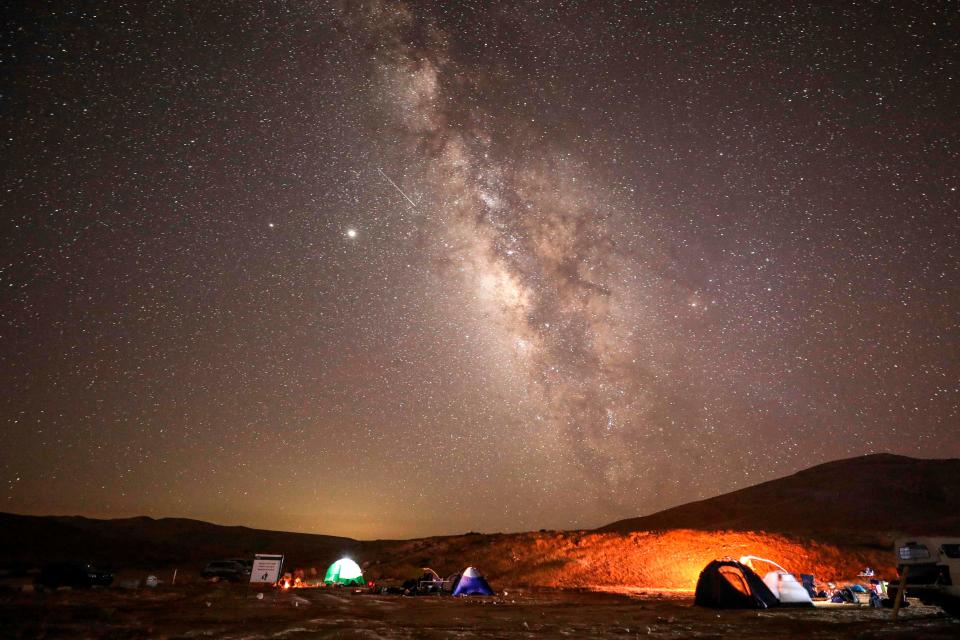 A Perseid meteor streaks across the sky above a camping site at the Negev desert near the city of Mitzpe Ramon on Aug. 11, 2020, during the Perseids meteor shower, which occurs every year when the Earth passes through the cloud of debris left by the comet Swift-Tuttle.