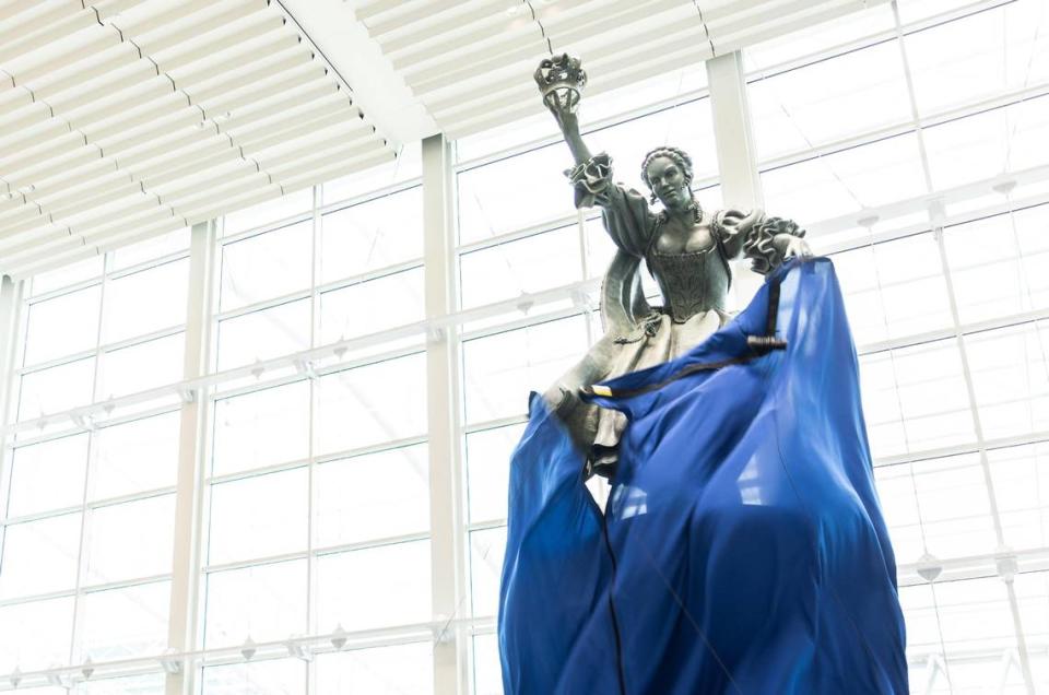 With the dropping of a tarp, people got their first look at the refurbished Queen Charlotte statue at Charlotte Douglas International Airport Friday.