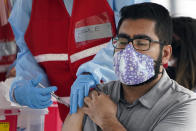 A man receives a COVID-19 vaccine at a site for health care workers at Ritchie Valens Recreation Center, Wednesday, Jan. 13, 2021, in Pacoima, Calif. (AP Photo/Marcio Jose Sanchez)