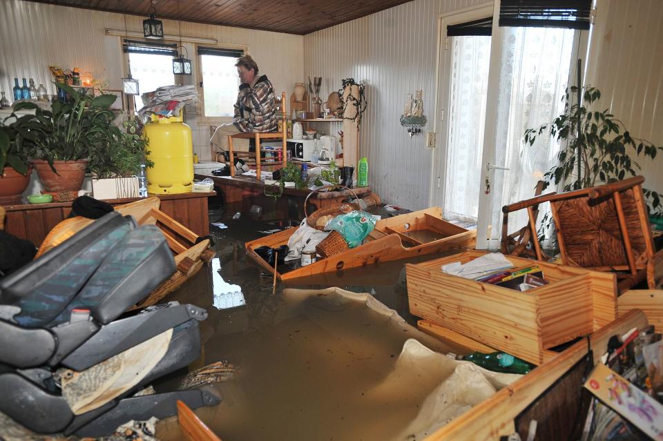 A woman sees the destruction in her house after Xynthia at La Faute-sur-Mer.