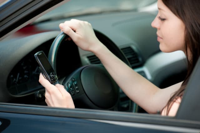 A girl texting while driving.