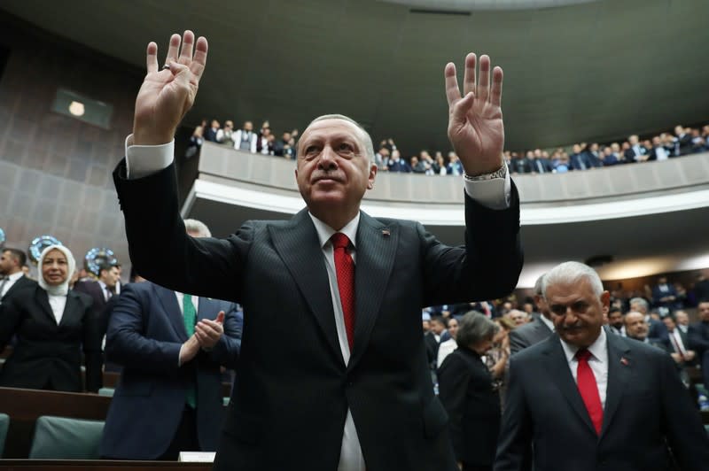 Turkish President Tayyip Erdogan greets members of parliament from his ruling AK Party as he arrives a meeting at the Turkish parliament in Ankara