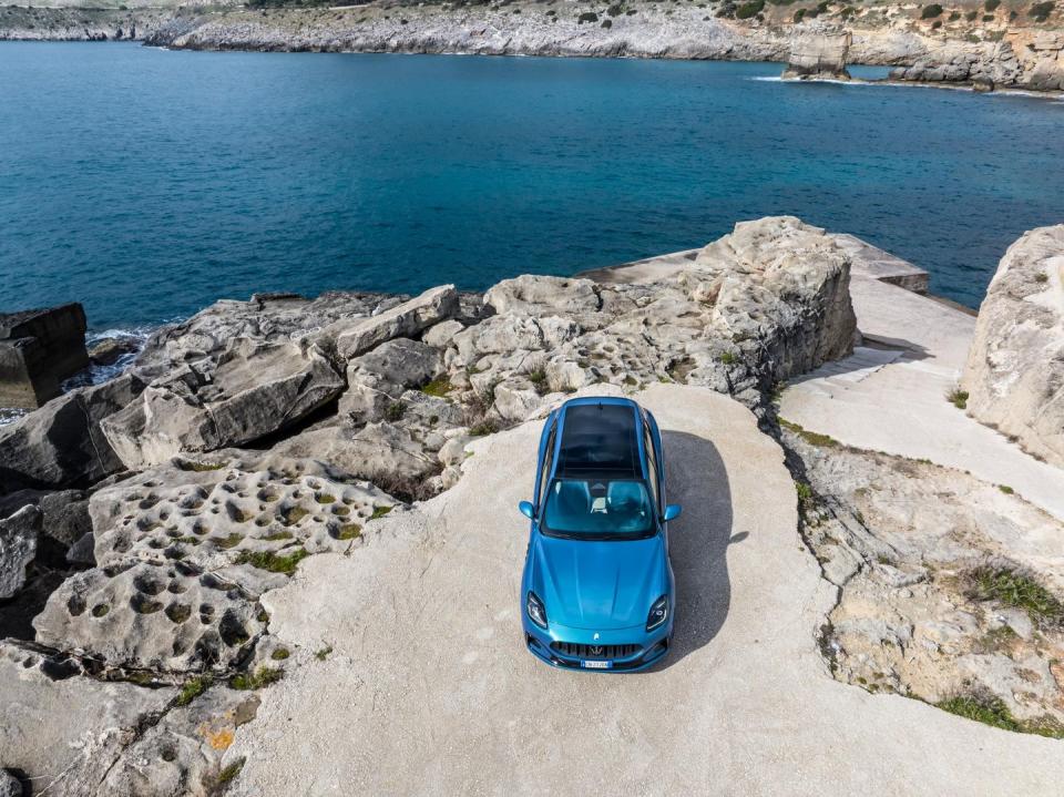 a blue car parked on a rocky beach