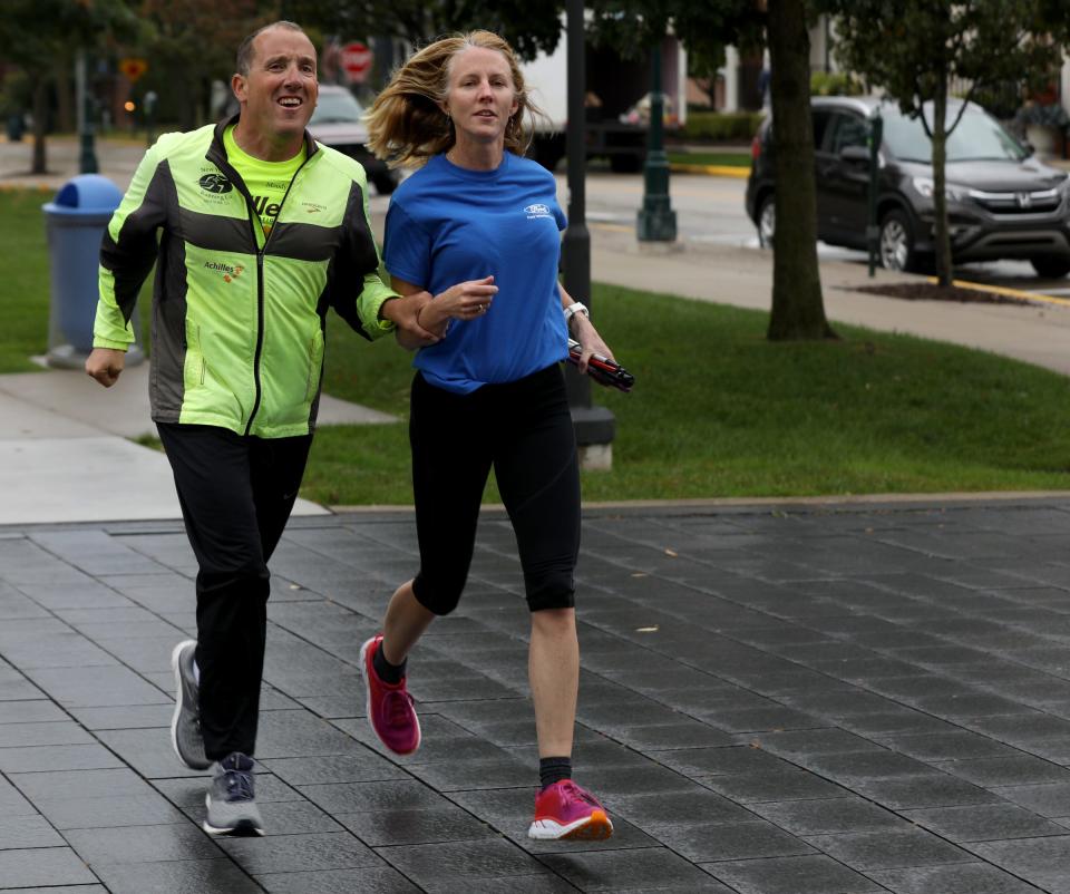 (L to R) Michigan Supreme Court Justice Richard Bernstein, who is blind, and Sara Reichert show off how she will help him run the 2019 Detroit Free Press/TCF Bank Marathon. They are seen here in Shain Park in Birmingham on Friday, October 11, 2019.