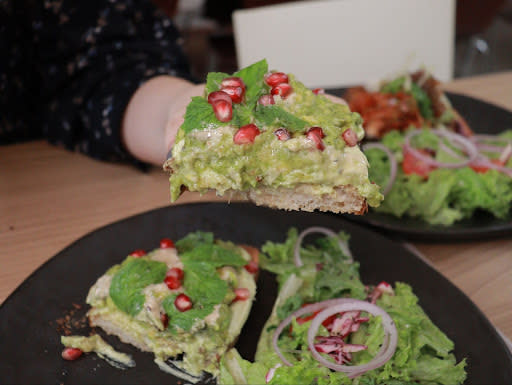 avo - holding up avo toast