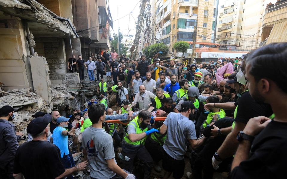 Rescuers carry a body at the scene of a missile strike in the southern suburbs of Beirut