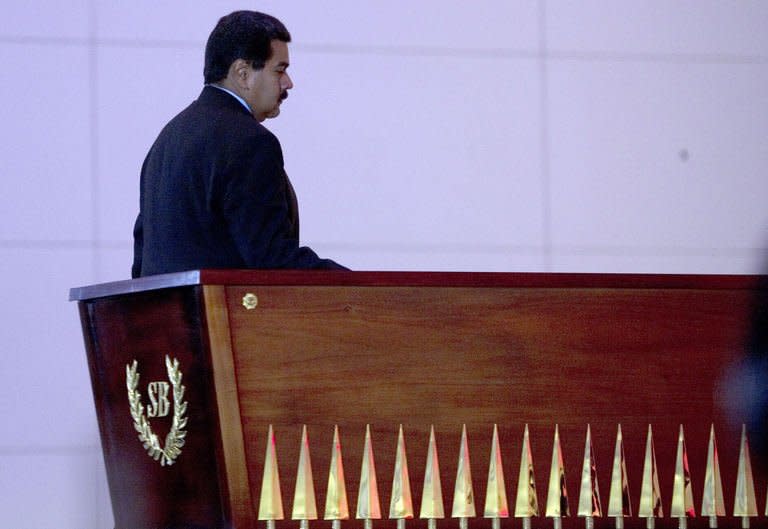 Venezuelan President Nicolas Maduro walks in front the coffin of Liberator Simon Bolivar during the opening of a new mausoleum in his honour, in Caracas on May 14, 2013. Maduro, a former bus driver and union organizer, was a member of Hugo Chavez's inner circle throughout the late leader's reign, serving as his vice president and foreign minister