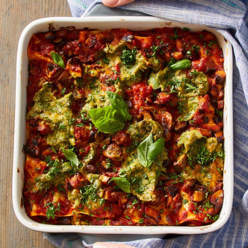 vegan lasagna with basil leaves in a white baking dish