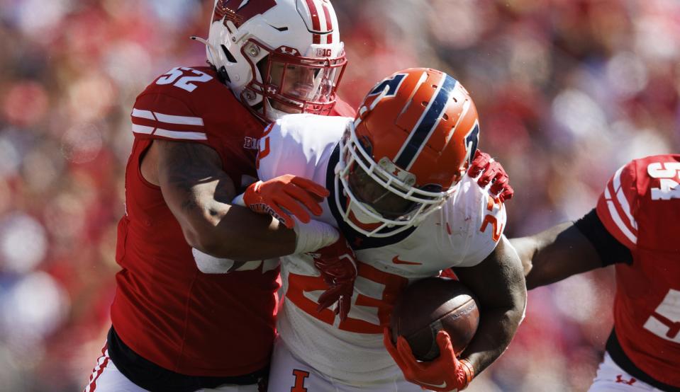 Oct 1, 2022; Madison, Wisconsin, USA; Illinois Fighting Illini running back Reggie Love III (23) is tackled by Wisconsin Badgers linebacker Kaden Johnson (52) during the third quarter at Camp Randall Stadium. Mandatory Credit: Jeff Hanisch-USA TODAY Sports