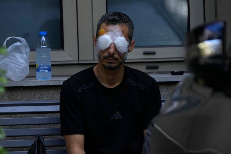 A man who was injured in the exploding devices attack sits outside the Eye Specialist hospital in Beirut (Copyright 2024 The Associated Press. All right reserved)