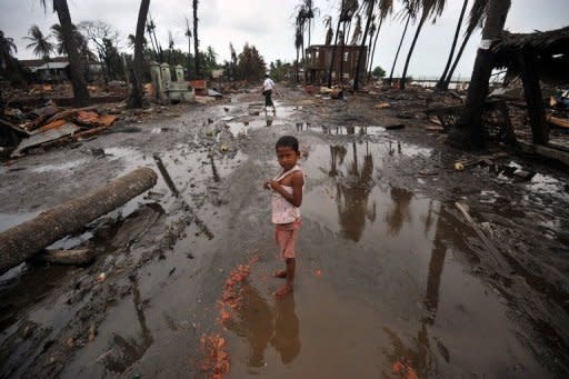 A child stands in a street lined with destroyed buildings following days of sectarian violence in Sittwe, capital of Myanmar's Rakhine state, in June. Charred stumps and scattered rubbish are all that remain of a once-bustling community in strife-torn western Myanmar, just one of many razed to the ground in recent communal violence