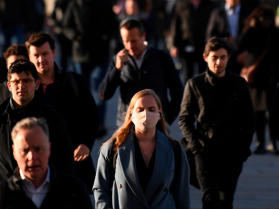 Commuters walk over London Bridge toward the City of London during the morning rush hour on 15 October 2020 (Photo by DANIEL LEAL-OLIVAS/AFP via Getty Images)