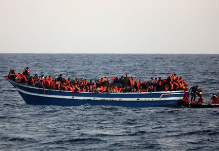 Spanish NGO Proactiva Open Arms rescuers help a migrant to board their RHIB as hundreds of migrants are seen overcrowding a wooden vessel drifting in central Mediterranean Sea off the Libyan coast, March 29, 2017 during a search and rescue operation. REUTERS/Yannis Behrakis