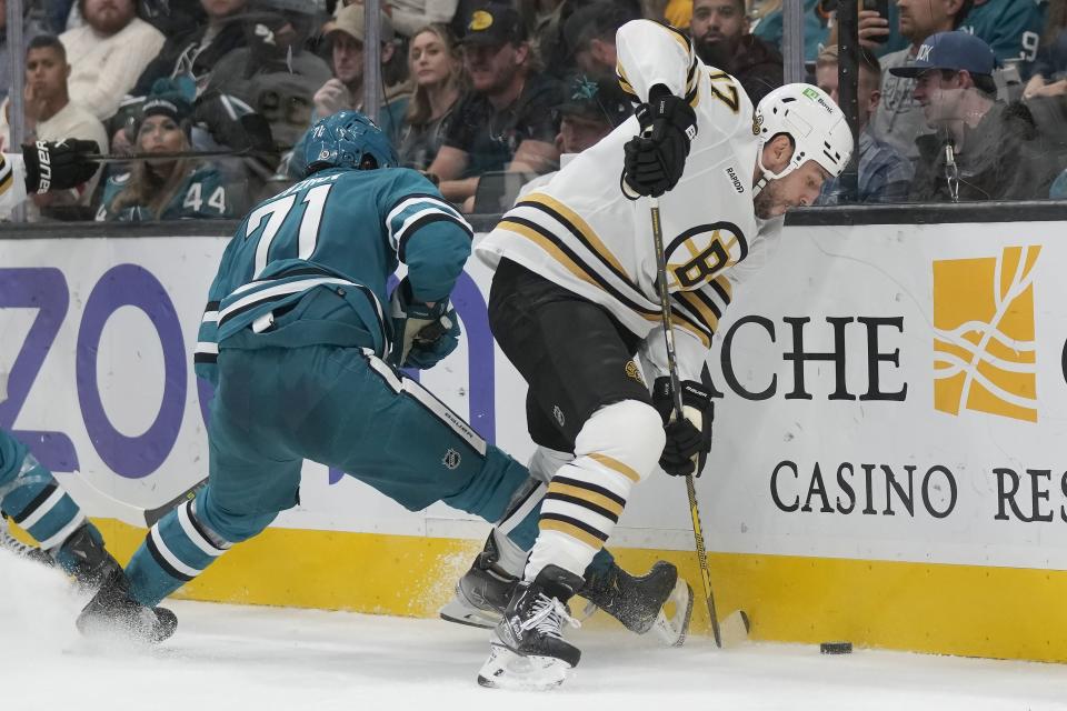 Boston Bruins left wing Milan Lucic (17) reaches for the puck in front of San Jose Sharks defenseman Nikolai Knyzhov (71) during the second period of an NHL hockey game in San Jose, Calif., Thursday, Oct. 19, 2023. (AP Photo/Jeff Chiu)