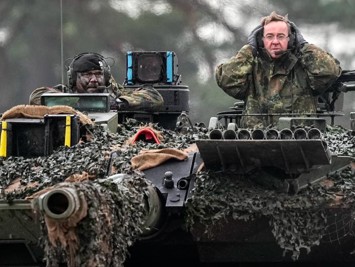 Boris Pistorius, right, sits on a Leopard 2 tank (AP)