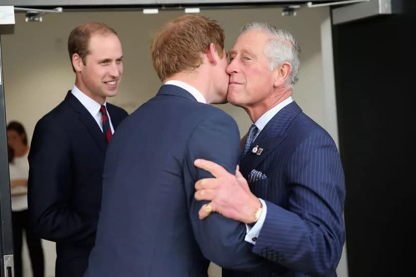 Prince Charles, Prince of Wales kisses his son Prince Harry as Prince William, Duke of Cambridge looks on ahead of the Invictus Games Opening Ceremony at Queen Elizabeth II Park on September 10, 2014 in London, England.