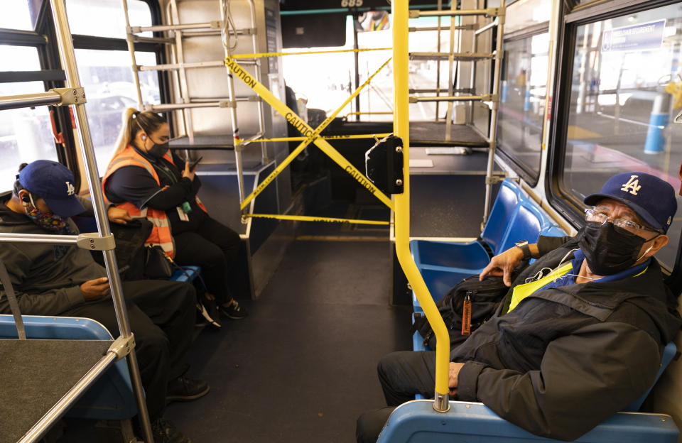 Airport workers take a shuttle bus between terminals at Los Angeles International Airport in Los Angeles, Wednesday, Nov. 25, 2020. Residents were urged to avoid nonessential travel during what is typically the busiest travel period of the year. Anyone entering California was advised to quarantine for two weeks. (AP Photo/Damian Dovarganes)