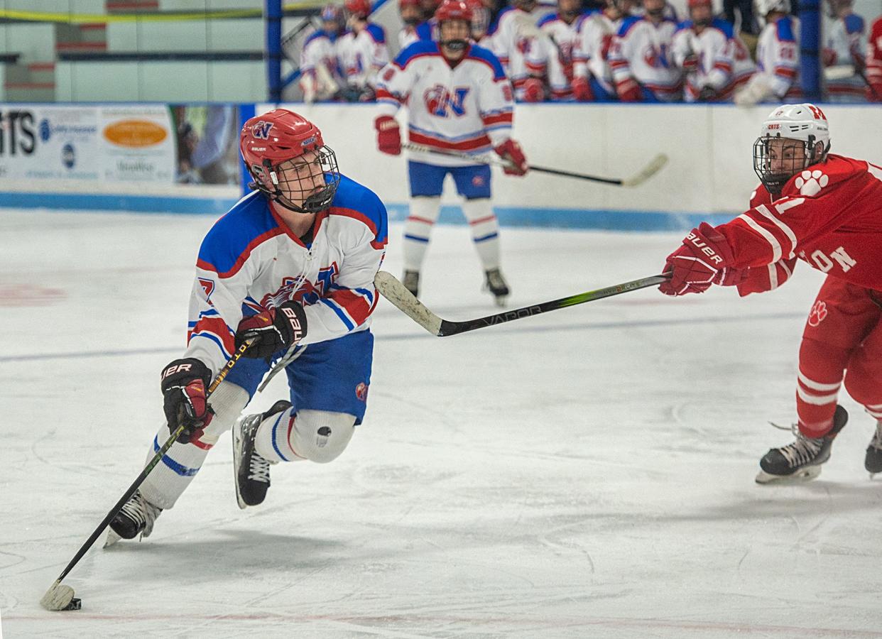 Natick High School junior Sam Hubbard lines up his second goal against Milton, at Chase Arena, Jan. 24, 2024. The Redhawks won, 3-1.