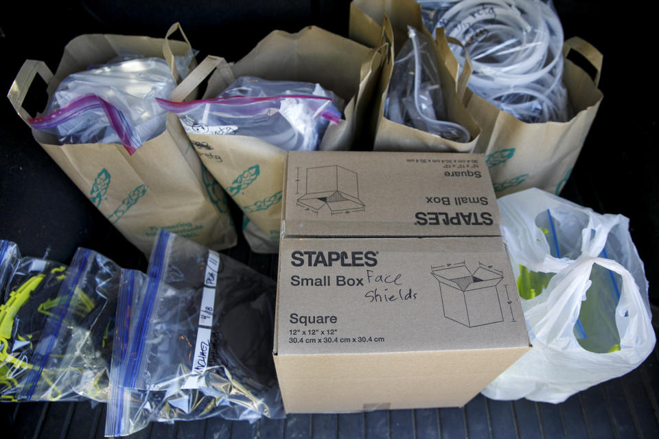 Pieces for medical face shields that were printed using personal 3D printers await transport, in Kensington, Md., Sunday, April 19, 2020, to the Eaton Hotel in downtown Washington where they will be assembled. (AP Photo/Jacquelyn Martin)