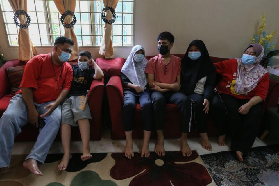 The four siblings, who lost their parents to Covid-19, are being taken care of by their uncle and aunt Normawati Ahmad (extreme right). — Picture by Ahmad Zamzahuri