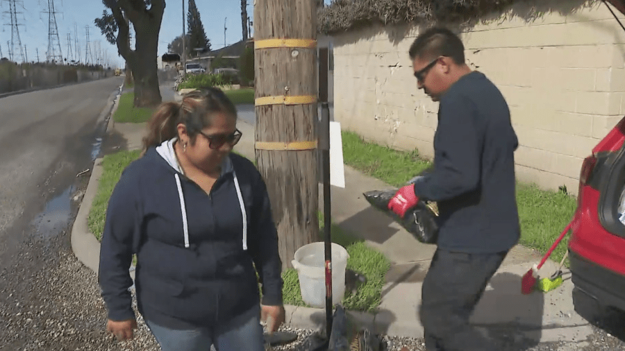 Daisy and Alex De La Rosa fill a pothole in Compton on March 7, 2024. 