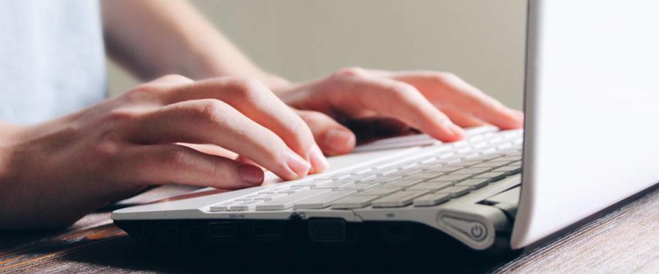 Close up of woman using laptop computer.