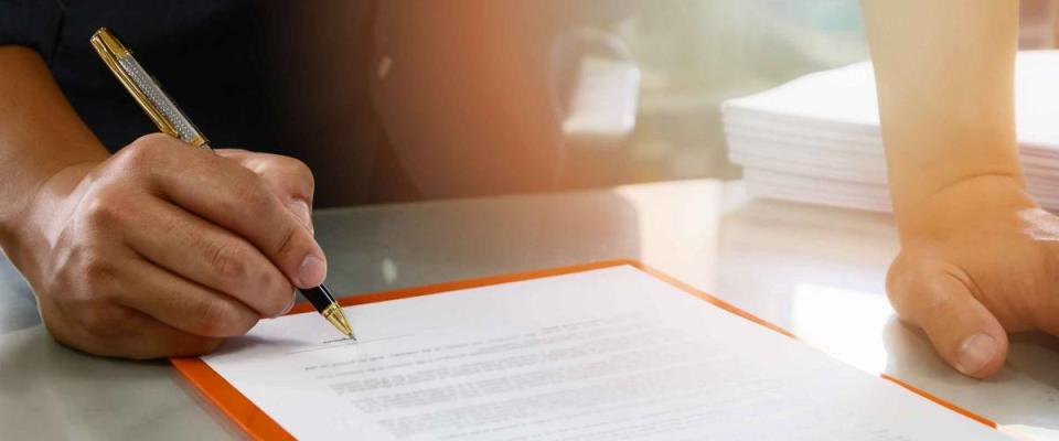 Close up of business man signing contract making a deal, business contract details. Businessman signing an official document