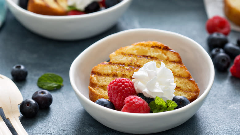 Grilled pound cake with berries and whipped cream in bowl