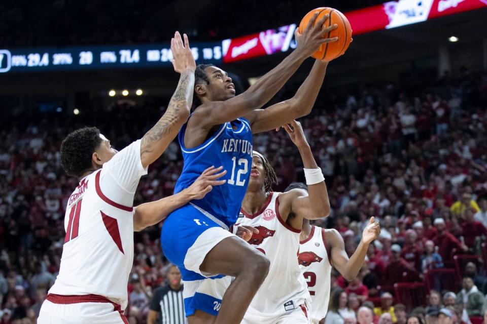 Kentucky guard Antonio Reeves (12) shoots the ball as Arkansas forward Jalen Graham (11) and Arkansas Razorbacks forward Chandler Lawson (8) defend during Saturday’s game at Bud Walton Arena in Fayetteville, Ark.