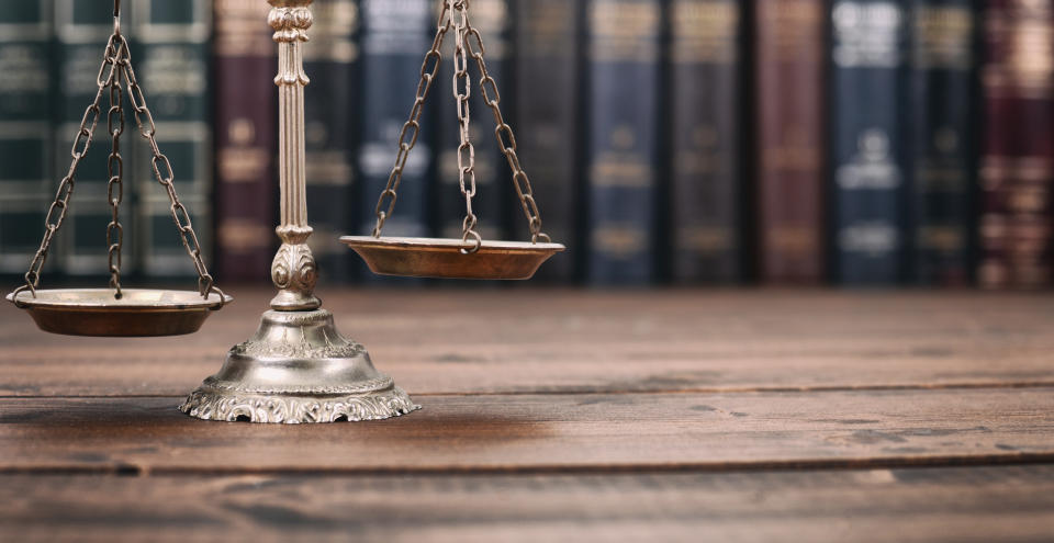 Scales of Justice l on a wooden background, Law library concept. Photo: Getty