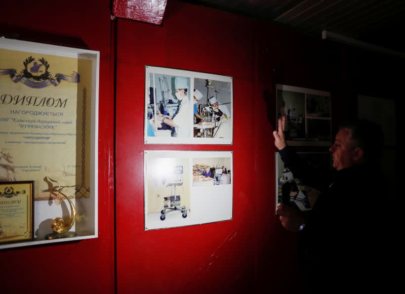 The plant's Acting Director Khodzitsky shows old photos at the Burevisnyk state-run military plant in Kiev