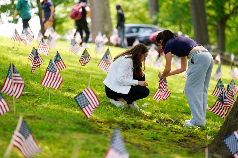 Students from Cliffside Park High School volunteer to place 2,000 American flags in the front lawn of the school to honor those who died in combat ahead of Memorial Day on Monday, May 22, 2023.