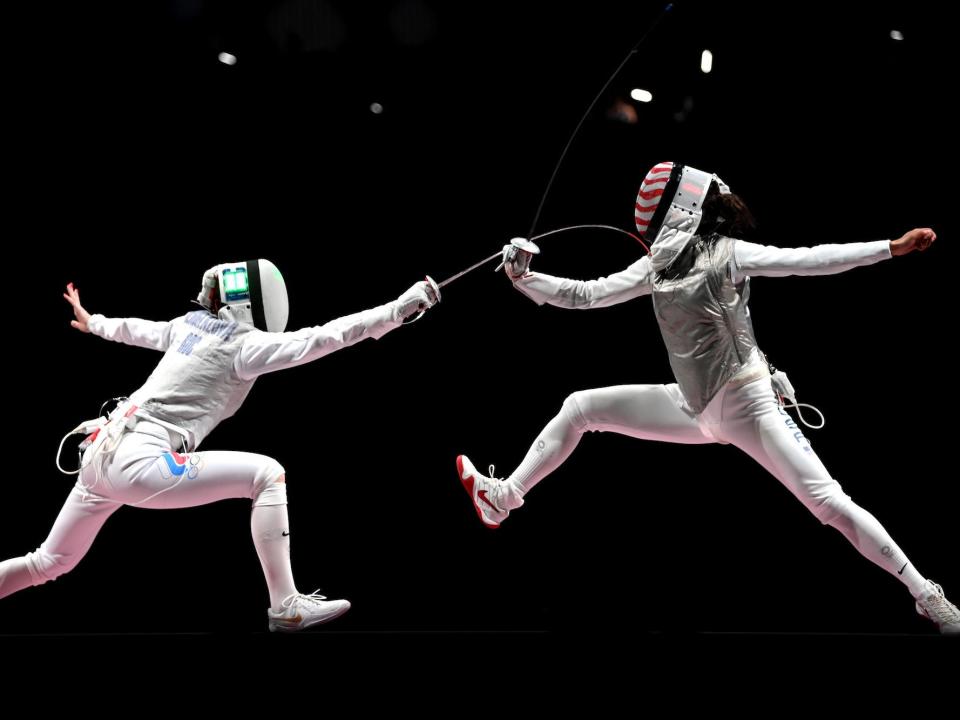 Two fencers lunge at the Tokyo Olympics.